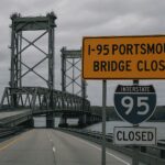 View of the i-95 portsmouth bridge closed | 2025, showing empty highway lanes, a steel vertical lift bridge, and a closure sign over a river.