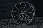 Close-up image of a sleek alloy wheel from Gram Lights placed against a dark background.