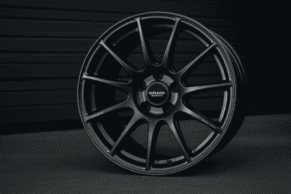 Close-up image of a sleek alloy wheel from Gram Lights placed against a dark background.
